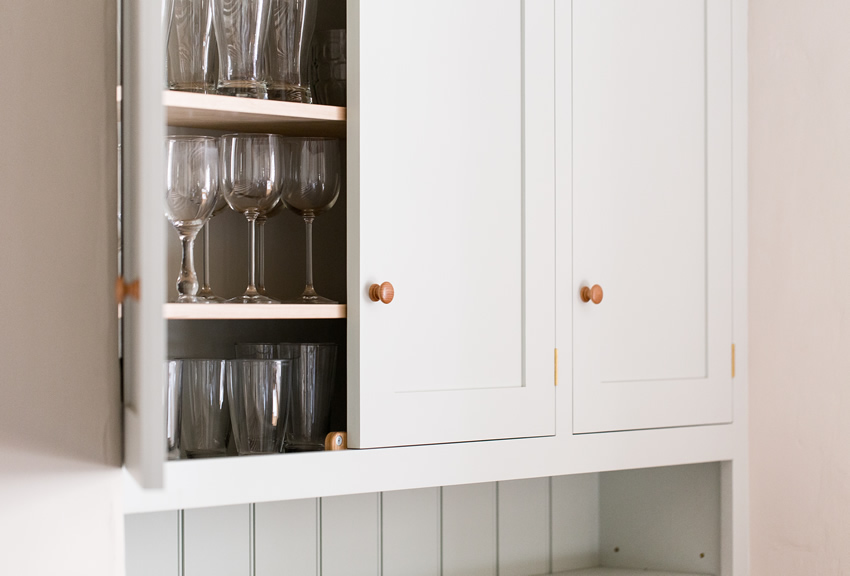 Shaker style kitchen. Birch plywood cabinets with hand painted hardwood frames (Farrow and Ball Estate Eggshell, Pale Powder).Traditional inset sink and integral dishwasher. Inset cooker hob and integral oven. 4.5m full stave oak worktop with upstand. Solid brass hinges and adjustable brass shelf supports. Solid oak dovetailed drawers with painted hardwood fronts. Hand turned beech knobs.