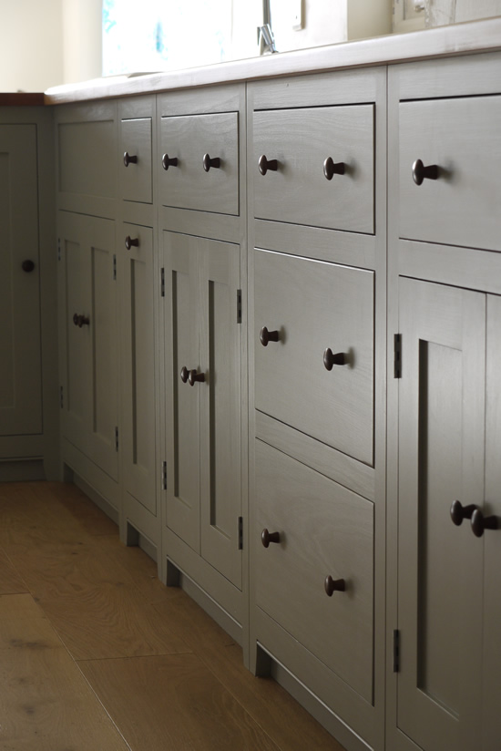 Shaker style kitchen. Birch plywood cabinets with hand painted hardwood frames (Farrow and Ball, Lamp Room Gray). Sink area with integral dishwasher, traditional ceramic inset sink and full stave beech top and upstand. Dovetailed drawers made of solid beech with painted hardwood fronts and walnut hand turned knobs.