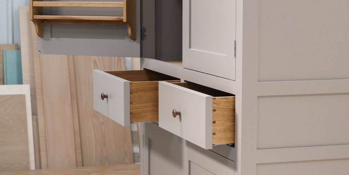 Larder cupboard handpainted in Farrow & Ball Estate Egshell - 'Charleston Gray'. Solid wood carcass with oak shelves, dovetailed drawers & spice racks. High quality solid brass hinges & shelf supports. Oak cornice & walnut knobs.