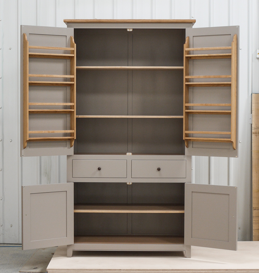 Freestanding larder cupboard handpainted in Farrow & Ball Estate Egshell - 'Charleston Gray'. Solid wood carcass with oak shelves, dovetailed drawers & spice racks. High quality solid brass hinges & shelf supports. Oak cornice & walnut knobs.