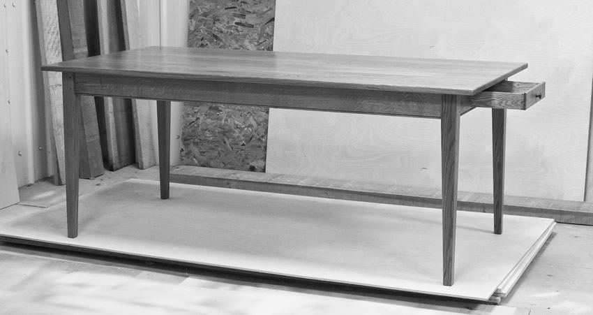 Oak Shaker style table with tapered legs and oak dovetailed drawer. The table is finished with hardwearing 'Osmo' hardwax oil.