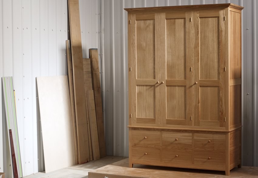 Oak wardrobe with solid oak carcass and panels. Oak faced birch ply shelves. Dovetailed oak drawers on high quality soft close runners. Bespoke cornice in solid oak and hand turned oak knobs. Solid brass hinges and adjustable shelf supports.